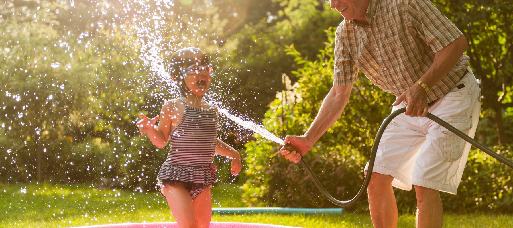 child playing in the water house with her grandparents