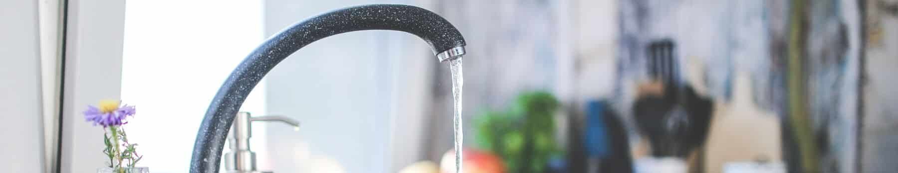 closeup of a faucet with water trickling out of it